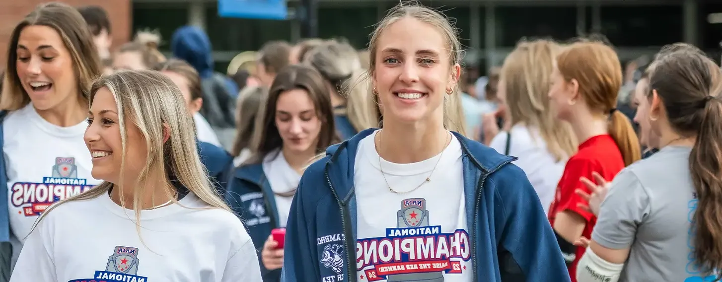 A group of female cheerleaders wearing their white Champions t-shirts.